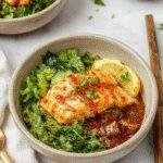 Colorful salmon bowls with spicy honey sriracha glaze, topped with fresh vegetables and herbs, served in a modern bowl setting.